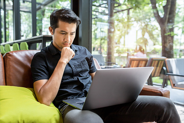 man looking at computer sitting on the chair