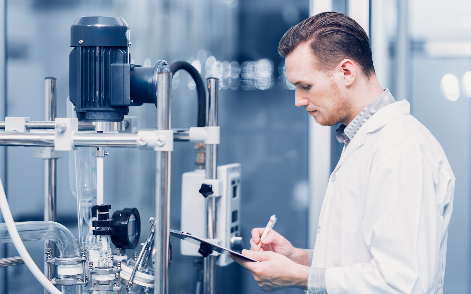 研究施設で装置を確認し記録する研究員