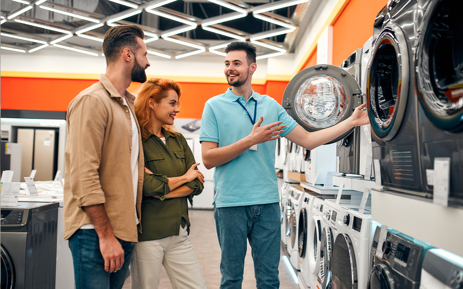 家電売り場で洗濯機を説明する店員と客