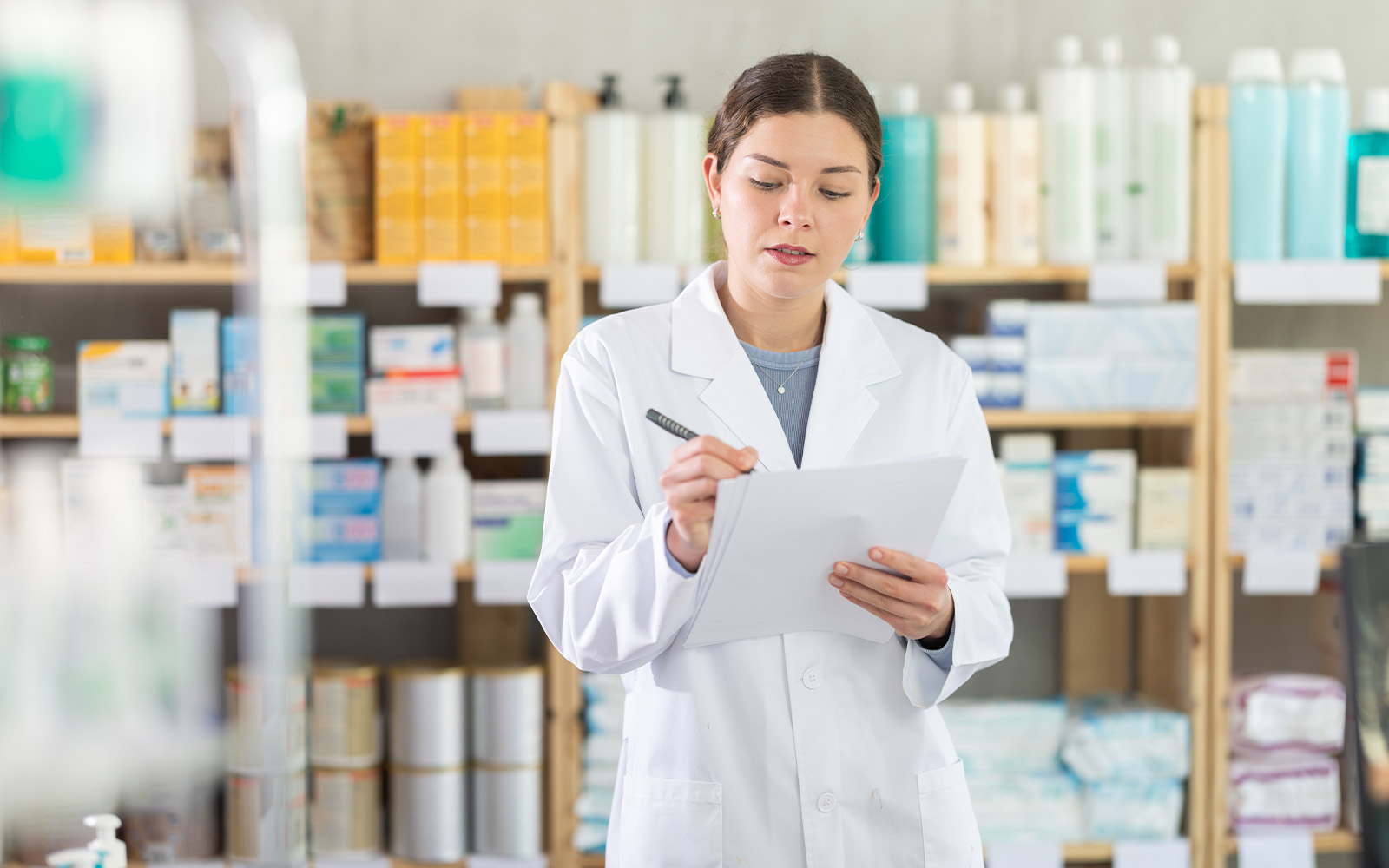 店舗で在庫を確認する白衣のスタッフ