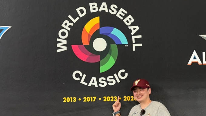 Hashimoto front of World Baseball Classic logo on a black wall with championship years displayed, photographed inside the stadium