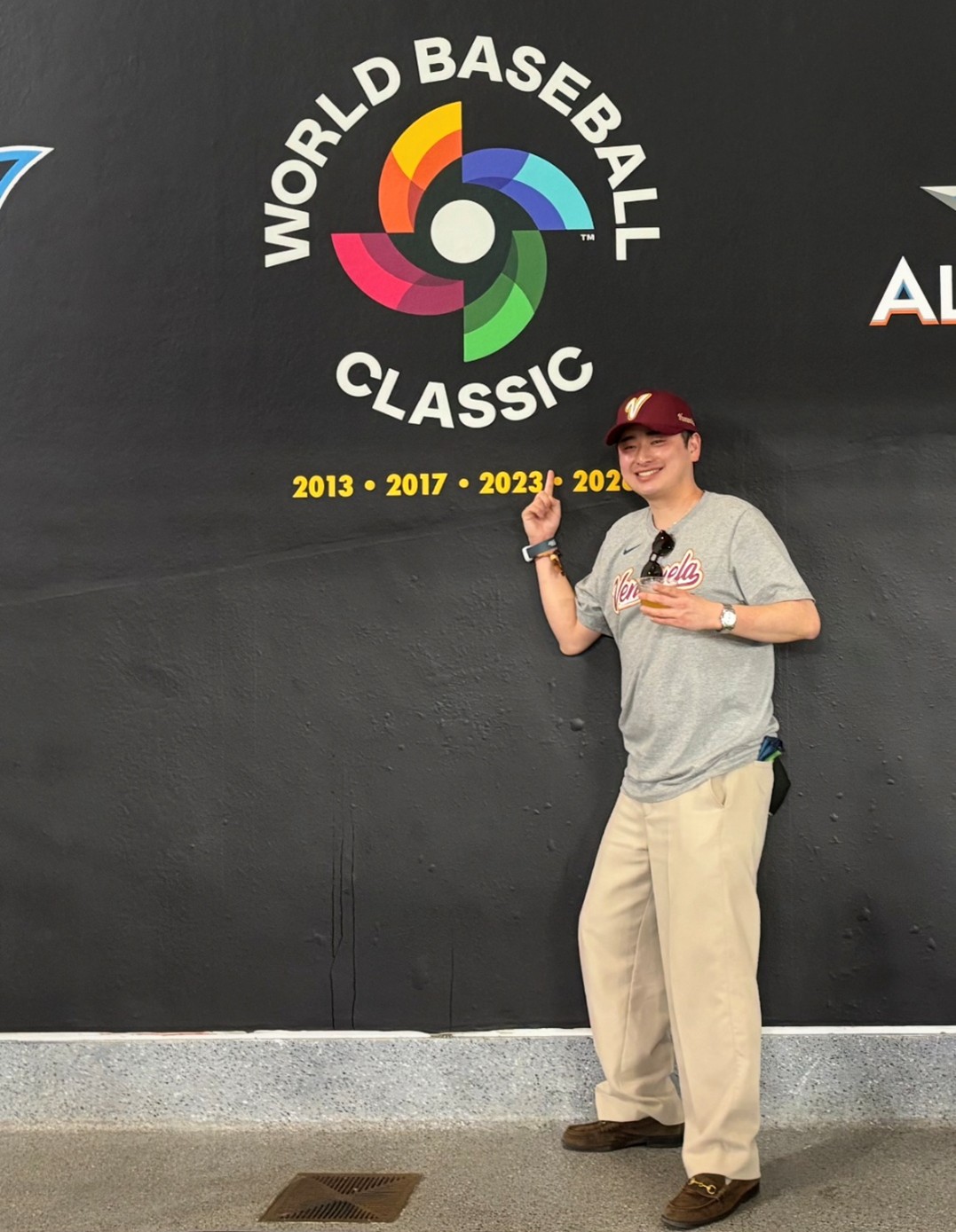 Celebrating fans wearing Venezuela colors inside the stadium after the World Baseball Classic final, holding phones and flag