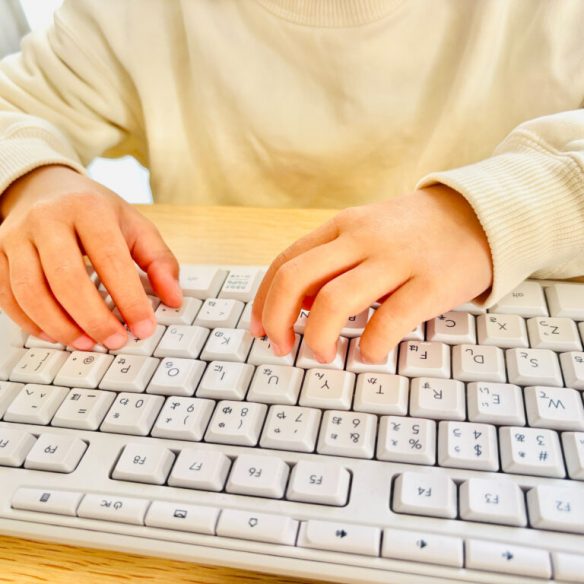 Child typing on keyboard