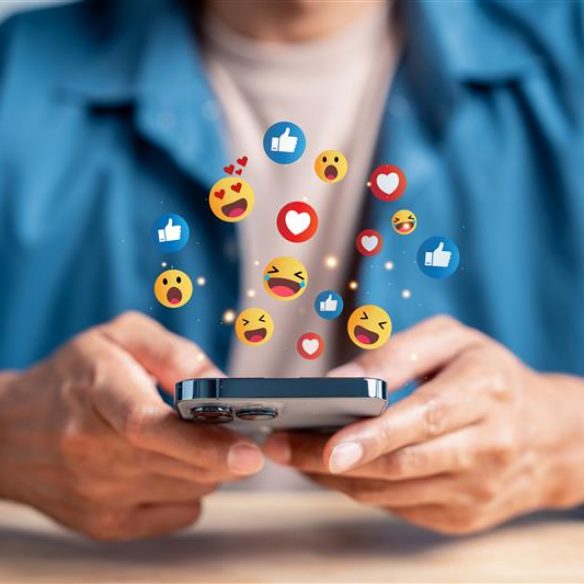 男性がスマホを持っていて、スマホからアイコンがあふれている