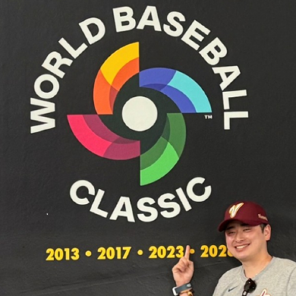 Hashimoto front of World Baseball Classic logo on a black wall with championship years displayed, photographed inside the stadium